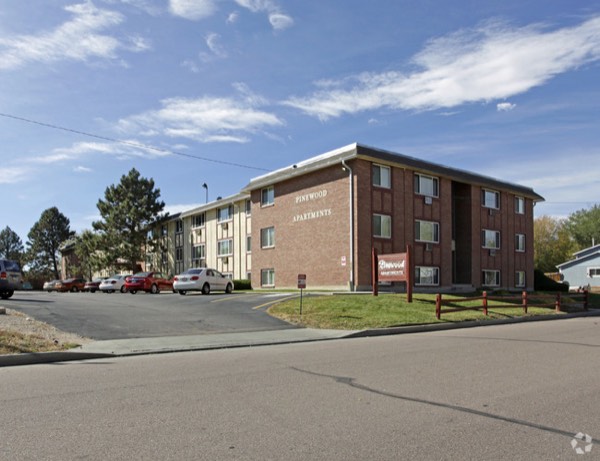 Wide view of Pinewood Apartments building with signage from the street